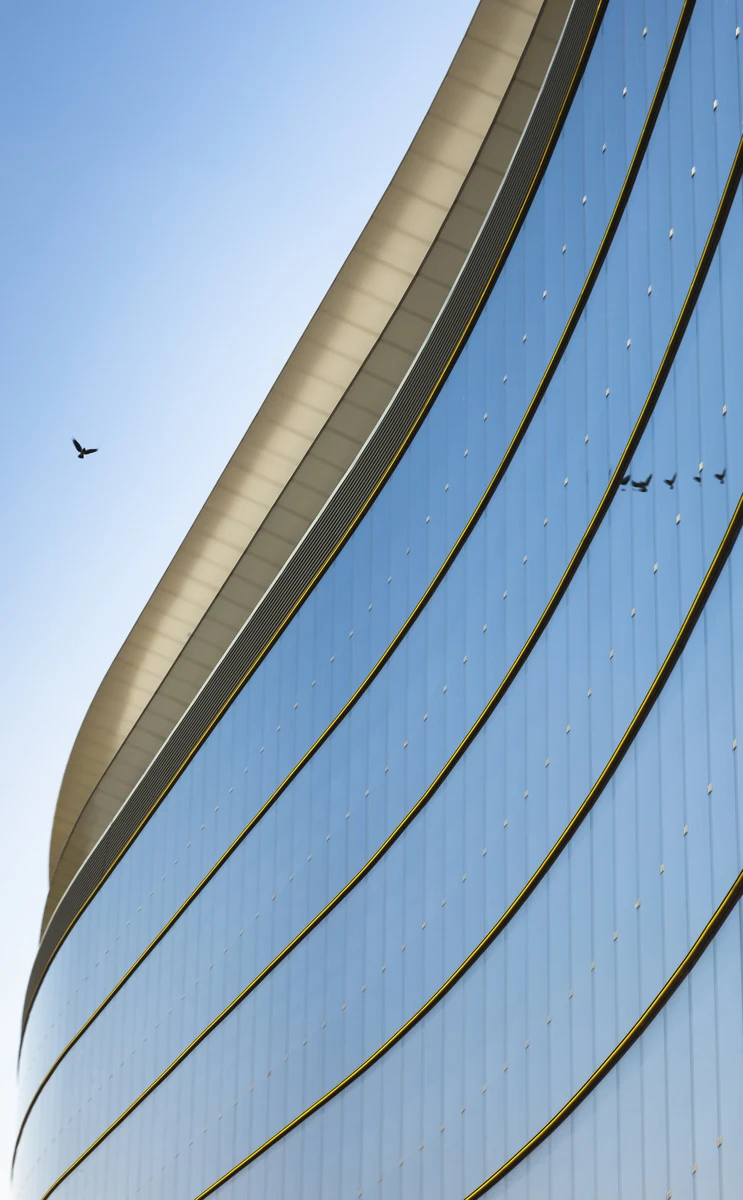 Curved glass facade of a modern office building — imagery from the 2019 Fundament website